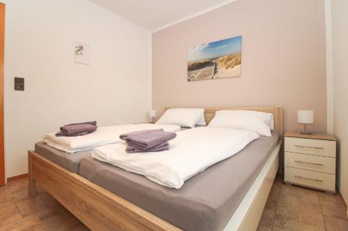 a bedroom with two beds with white sheets at Deichbrise in Greetsiel