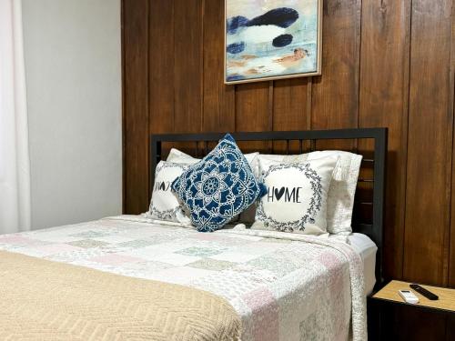 a bedroom with a bed with blue and white pillows at Retiro Arenal in Fortuna