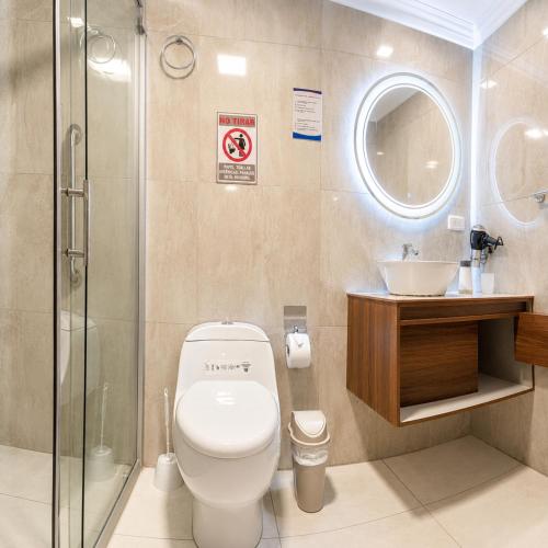 a bathroom with a toilet and a sink and a shower at Plaza Lobos in Puerto Baquerizo Moreno