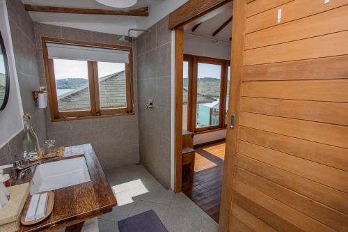 a bathroom with a sink and a wooden door at Indigo Blue Ceningan in Nusa Lembongan