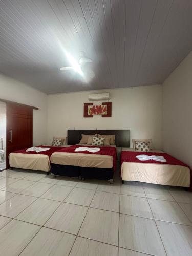 a bedroom with two beds and a ceiling at Refúgio Mix Pousada com 3 suítes e 9 camas in Vilhena