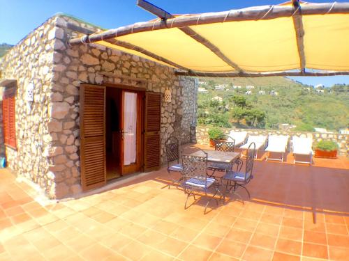 a patio with a table and chairs on a balcony at Torre Turbolo Apartments in Massa Lubrense
