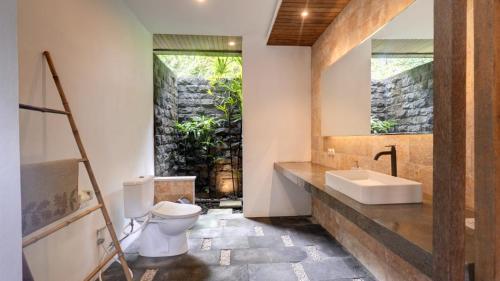 a bathroom with a sink and a toilet at Villa Maeni in Munggu