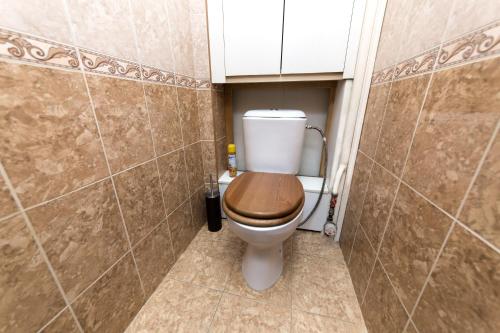 ein Badezimmer mit einem WC und einem Holzsitz in der Unterkunft Hotel Voikovsky in Moskau