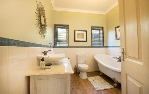 un bagno con lavandino, vasca e WC di Die Blou Huis a Clarens