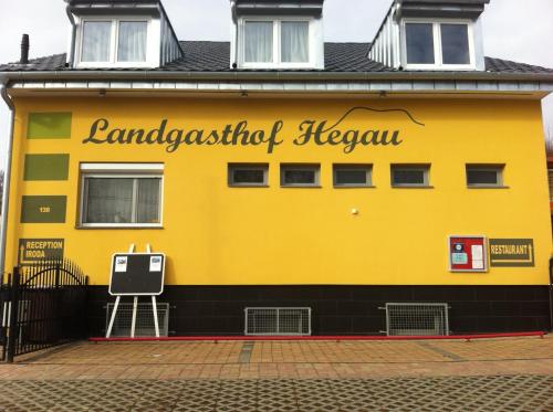 een geel gebouw met een bord erop bij Landgasthof Hegau in Dunaszekcső