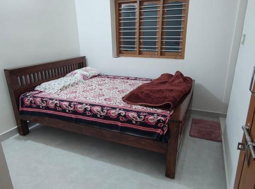 a small bed in a room with a window at Tranquil Breeze Stay in Napoklu