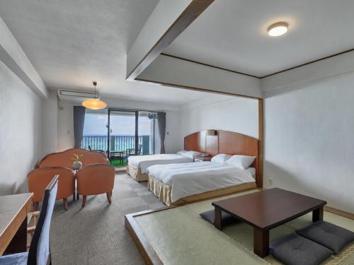 a hotel room with two beds and a table at 恩納マリンビューパレス in Onna