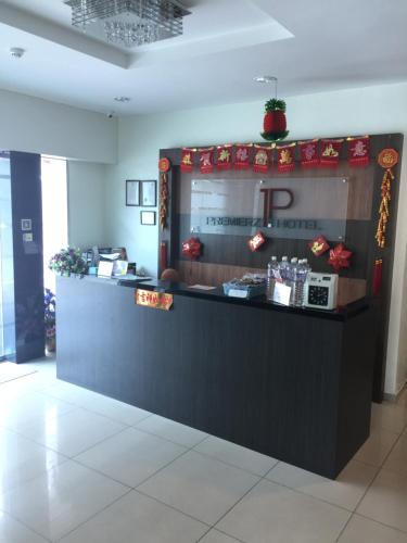 a restaurant with a black counter with a reception desk at Premierz Hotel in Labuan