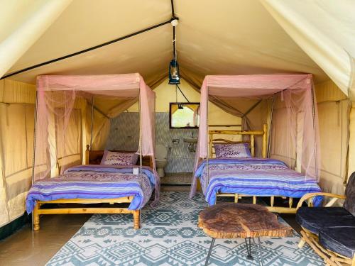 a room with two beds in a tent at Eschato tented camp in Gilgil