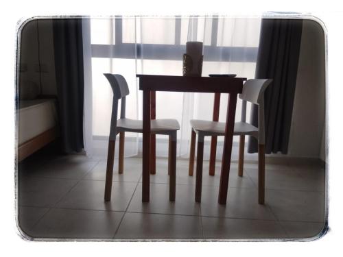 a table and two chairs sitting next to a window at Nuez de la Isla "Hana Apart" Mono C Individuales - SAN ROQUE a 3 cuadras! - in Paraná