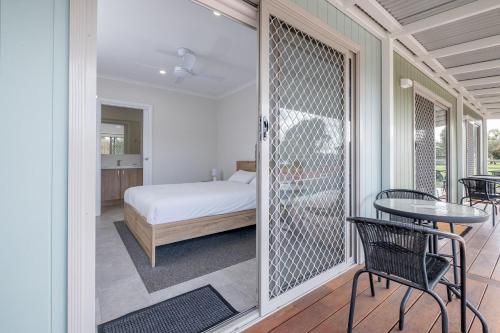 a bedroom with a bed and a table on a balcony at Beaufort Lake Caravan Park in Beaufort
