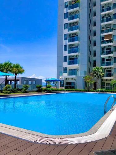 a large blue swimming pool in front of a building at BEER HOMESTAY Huế - FREE POOL & GYM in Hue