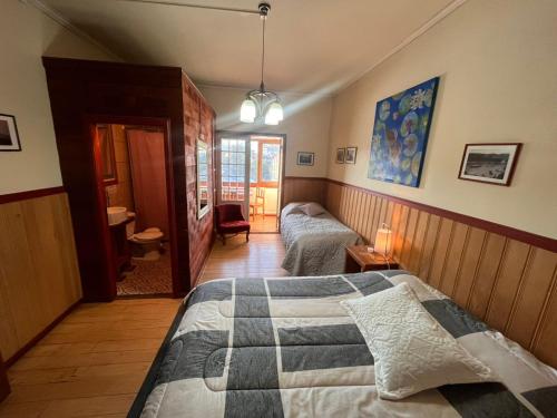 a bedroom with two beds and a hallway at Amura Hostel in Puerto Varas
