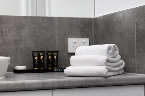 a pile of towels sitting on a counter in a bathroom at The Lime Loft, Rooftop Views in Mildura's CBD in Mildura