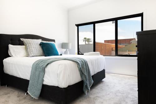 a bedroom with a large bed and a large window at The Lime Loft, Rooftop Views in Mildura's CBD in Mildura