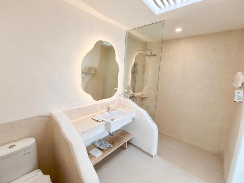 a white bathroom with a sink and a mirror at Villa Nala Uluwatu by LODGELINK BALI in Uluwatu