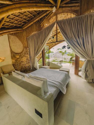 a bedroom with a bed in a room with curtains at Mandala Eco Resort Lombok in Selong Belanak