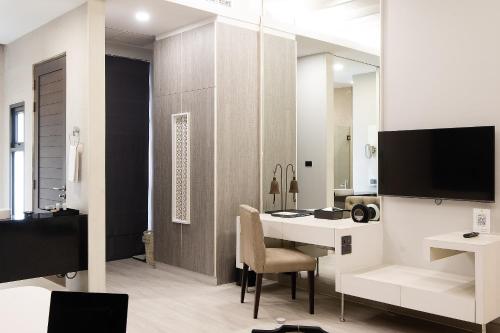 salon z biurkiem i telewizorem w pokoju w obiekcie De Chai Colonial Hotel & Spa w mieście Chiang Mai