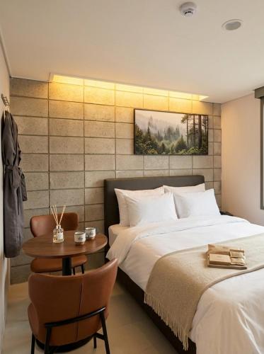 a bedroom with two beds and a table with a chair at 스테이큐브 505 in Chŏnju-yŏk