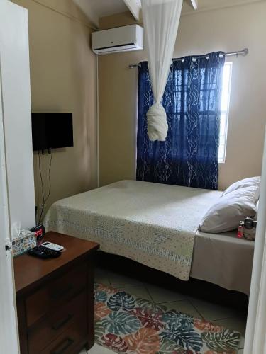 a small bedroom with a bed and a window at Fano's Oasis in Castries