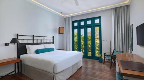 a bedroom with a bed and a table and a desk at Santarena Hotel at Las Catalinas in Playa Flamingo