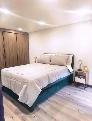 a bedroom with a large bed and a wooden floor at Faro 4, Jaime Duque, Autódromo Tocancipá in Tocancipá