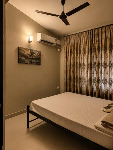 a bedroom with a bed and a ceiling fan at Goan Casa Feliz in Calangute
