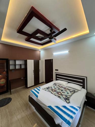 a bedroom with a large bed with a ceiling at Kurishingal Guest House in Mararikulam