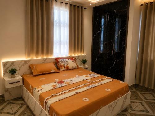 a large bed in a room with a window at Edmundson Villa Apartment in Ejisu