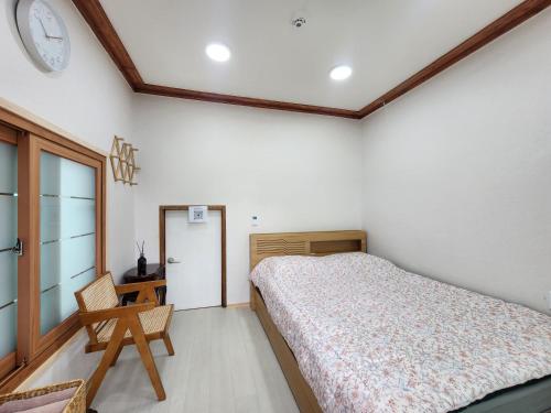 a bedroom with a bed and a clock on the wall at Hanok Stay Ohneul in Gyeongju