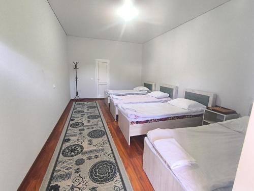 a room with four beds and a rug at Амир in Arkit