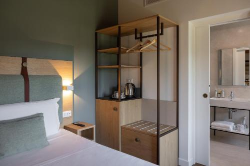 a bedroom with a bed and a cabinet and a sink at Hotel Venice Resort Airport in Tessera