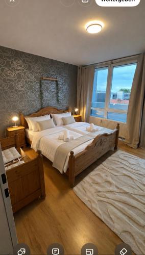 a bedroom with a large bed and a large window at FeWo am Deich im Columbus Center mit Pool und Aufzug in Bremerhaven
