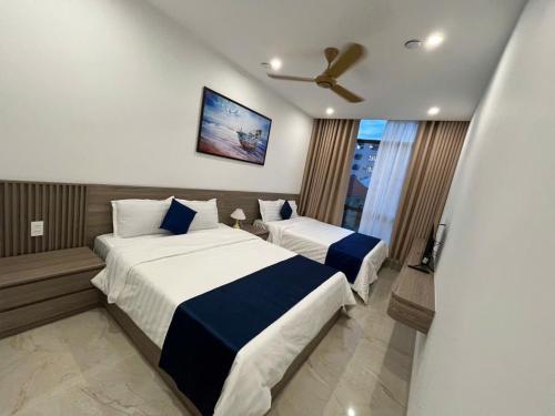 a hotel room with two beds and a ceiling fan at Sealand hotel & spa in Dong Hoi