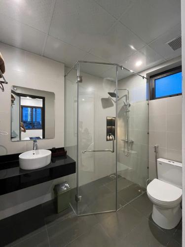 a bathroom with a glass shower and a toilet at Sealand hotel & spa in Dong Hoi