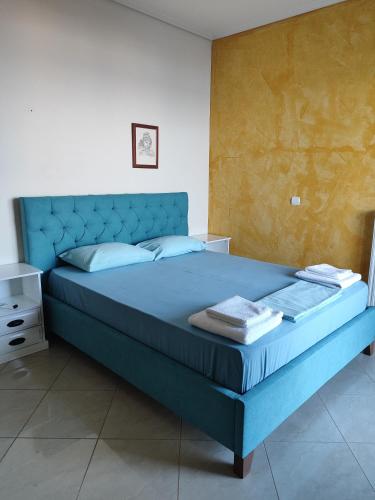 a blue bed with a blue headboard in a bedroom at Sunshine in Skala Marion