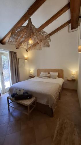 a bedroom with a large bed and a chandelier at Stazzu La Vigna Di Maria in Aglientu