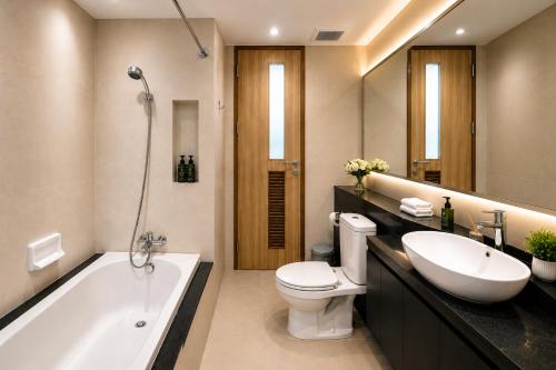 a bathroom with a tub and a toilet and a sink at Olive Hotel & Residence Bangkok Sukhumvit 101 near True Digital Park in Bangkok