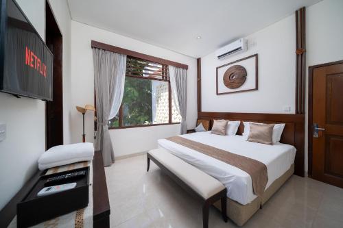 a bedroom with a bed and a tv in it at Uluran Villa Uluwatu in Uluwatu