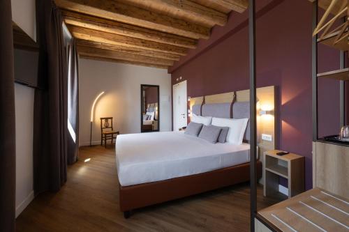 a bedroom with a white bed and a purple wall at Hotel Venice Resort Airport in Tessera