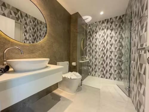 a bathroom with a sink and a toilet and a mirror at Title Naiyang Walk To Beach C111 in Nai Yang Beach