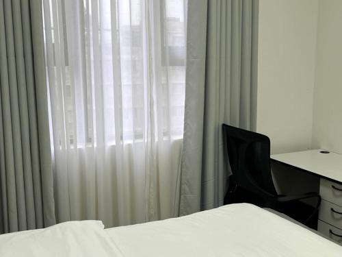 a bedroom with a desk and a chair next to a window at Serenity Residences 1BR Ruaka Near Two Rivers & UN Gigiri in Nairobi