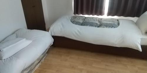 a bedroom with a bed with pillows and a window at メープル桑園駅202 in Sapporo