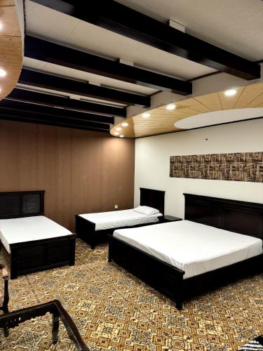 a room with three beds in a room at Highland Lodges Balakot in Bālākot