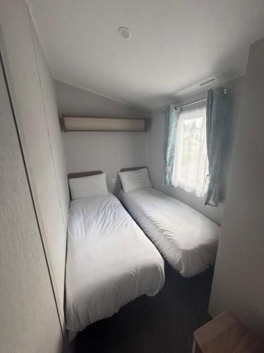 two beds in a small room with a window at Explorer45 in Lytchett Minster