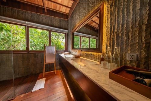 a bathroom with a counter with a sink and a mirror at Kropak Sidemen in Sidemen