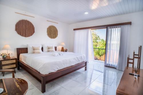 a bedroom with a large bed and a balcony at Pondok Bingin Guest House in Bingin Beach