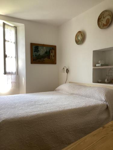 a white bedroom with a bed and a window at Alle Fucine in Mallare