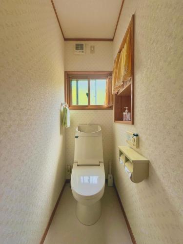 a bathroom with a toilet with a phone on the wall at Takumisou 2 in Kiso